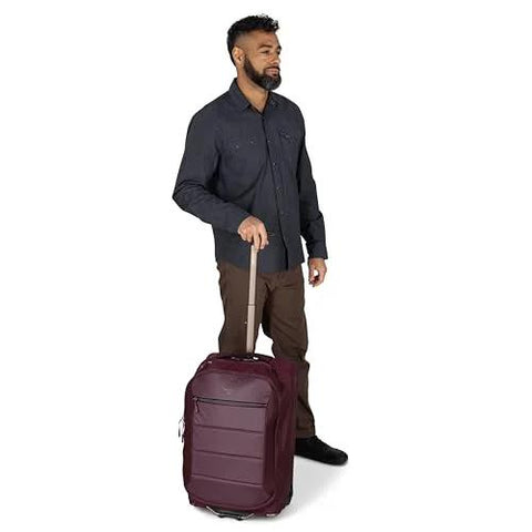 Osprey Ozone 2-Wheel Carry-On luggage in burgundy with extended retractable handle, rolling on two wheels