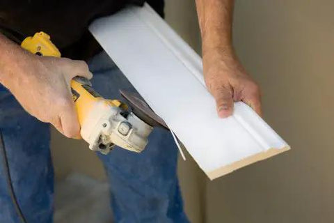 Heavy Duty Aluminum Carpentry Scribe Tool With Dead On Built In Stud Detector And Eight Exact Offsets For Swift Wall Marking Easy Corner Reach And Knockout Cabinet Installations being used to cut trim.