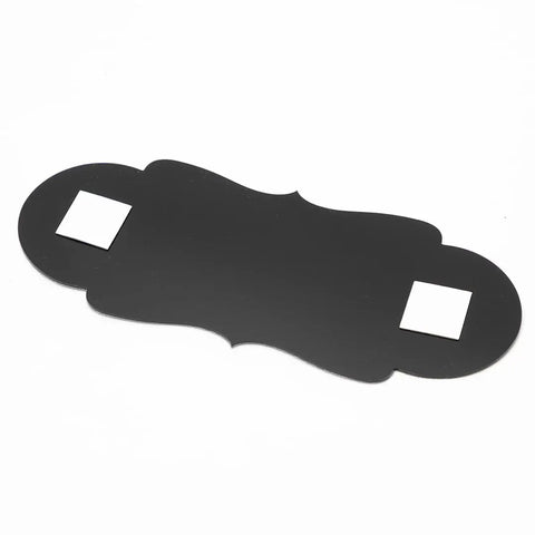 Blank black decorative sign in a unique shape with adhesive strips on the back, design not visible.