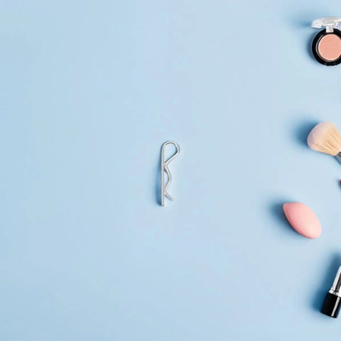Heavy Duty 8pc Stainless Steel R Cotter Pins Locking Fasteners on blue background with makeup items, showcasing size and shine.