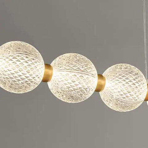 Modern Minimalist Nine Light Brass Pendant Light With Sleek Magic Bean Profile Delivering Lowkey Stunning Vibes For Cafe Bar Restaurant Or Kitchen Island solid heavy duty construction showcasing three textured glass bulbs.