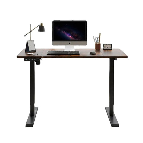 Rock Solid Electric Standing Desk With Dual Motor Lift System For Heavy Duty Home Office And Gaming Setup Adjustable Height Computer Table In Rich Rustic Brown Finish supports setup with computer, lamp, and stationery.