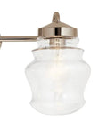 Close-up of a clear glass shade fixture from Janiel 24 Inch Three Light Vanity Light With Clear Glass Shades In Classic Bronze Finish