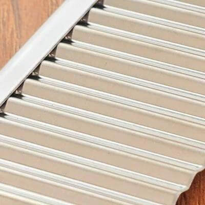 Close-up of stainless steel wavy blade vegetable slicer for crinkle-cut fries.