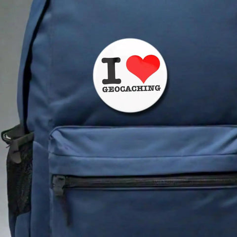 Outdoor Adventure Pin Set Five Pack Two And A Quarter Inch Round Metal Badges For Geocaching Fans on a blue backpack.