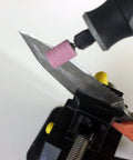 20 Piece Rotary Grinding Stone Bits Set With One Eighth Inch Shank sharpening a knife blade with pink abrasive stone