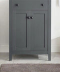 Elegant gray bathroom cabinet with dual doors and sleek lines on a tiled floor.