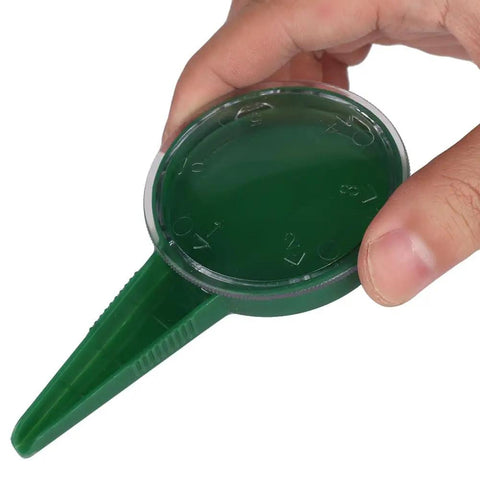Hand holding Army Green Seed Spreader Garden Seeding Tool With Adjustable Dial For Even Planting, close-up view