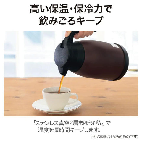 Hand pouring coffee from Stainless Steel Vacuum Carafe 1.9 L With One-Touch Pour, Tank-Grade Build, Brown into cup