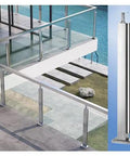 Stainless Steel 304 Railing Post Kit For Outdoor Decks And Stairs Featuring Adjustable Mounts And A Brushed Silver Finish Fit For 10 To 12 Mm Glass Panels shown on a modern deck overlooking a pool.