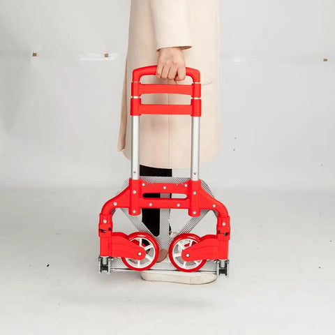 Person holding a red Slick Folding Hand Truck Dolly With 165 Lb Capacity And Telescoping Handle lightweight cart with wheels.