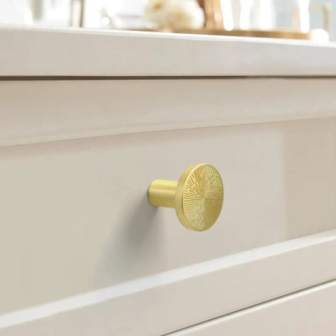 Close-up of Six Pack Engraved Boss Grade Brushed Brass Kitchen Cabinet Knobs One Inch Round Solid Dresser Drawer Pulls on drawer