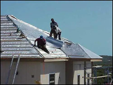 Men installing Heavy Duty Reflective Insulation Roll With Foam Core Covers 400 Square Feet on a rooftop for thermal barrier.