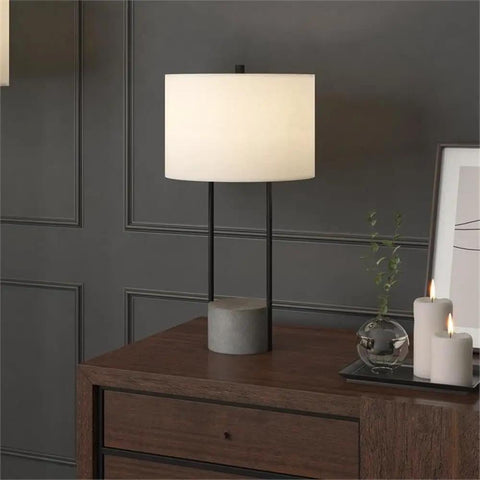 65.5 Inch Tall Floor Lamp With White Drum Shade In Blackened Bronze And Concrete Finish on wooden dresser