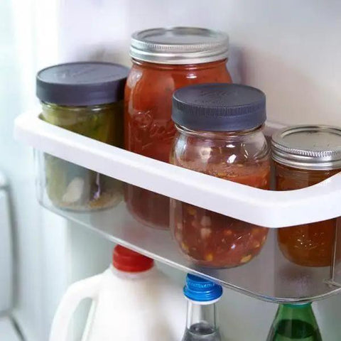 Refrigerator shelf with mason jars sealed by Awesome Leak Proof Plastic Lids for Wide Mouth Mason Jars For Canning Pickling Juices Jams And Jellies BPA Free Made In USA Ridge Edge Grip Great For Gifting And Crafting Fits Most Wide Mouth Jars