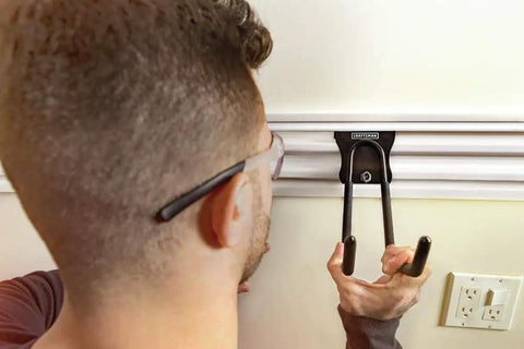 Person installing VersaTrack Garage Storage Rail With Twenty Piece Mounting Accessories For Drywall Studs And Masonry Pegboard Ready Patented Hooktite Latching on wall