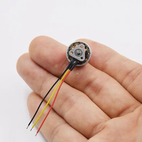 Person holding 1103 Beefy High Speed Brushless Motor 15000KV for RC drones and micro fixed wing planes, showing small size.