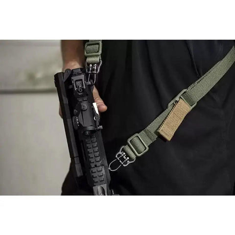 Gun held with Game Changer Universal QD Wire Loop That Locks Dead Sure On 1.25 Inch Slings Mounts Plug And Play To Keymod.