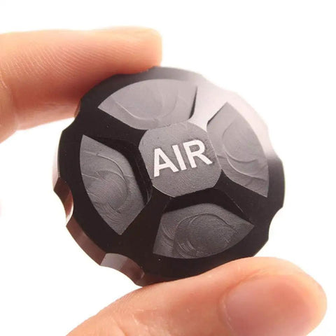 Hand holding CNC Aluminum Mountain Bike Fork Cap Protector Black for Front Suspension Upgrade Lightweight Yet Tough Valve Cover Shield