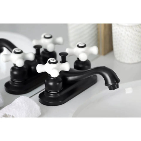 Black centerset lavatory faucet with porcelain cross handles next to a pop-up drain in a bathroom setting