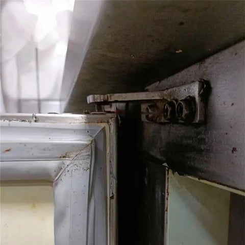 Close-up of a refrigerator hinge in need of repair, highlighting the wear on a door using 4 Piece Refrigerator Hinge Set with 35mm wheelbase.
