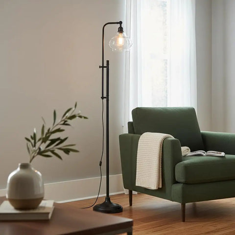 Tall Industrial LED Floor Lamp With Adjustable Head And Rustic Glass Teardrop Shade, Black Finish beside green sofa