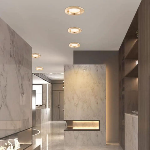 Top Shelf 9 Pack 3 Inch LED Recessed Downlights With Sleek Baffle Trim illuminating a modern hallway with marble walls.