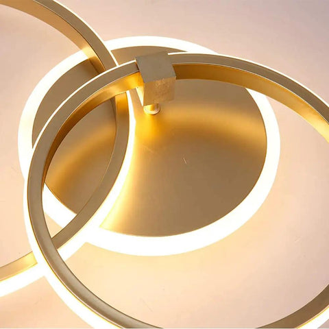Close-up of Modern LED Ceiling Light Flush Mount 106W With Six Ring Circle Design, Gold Acrylic Chandelier glowing in cool white.