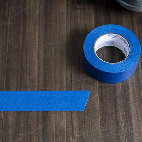 Duck Brand Clean Release painter's tape roll with blue tape strip on wood surface