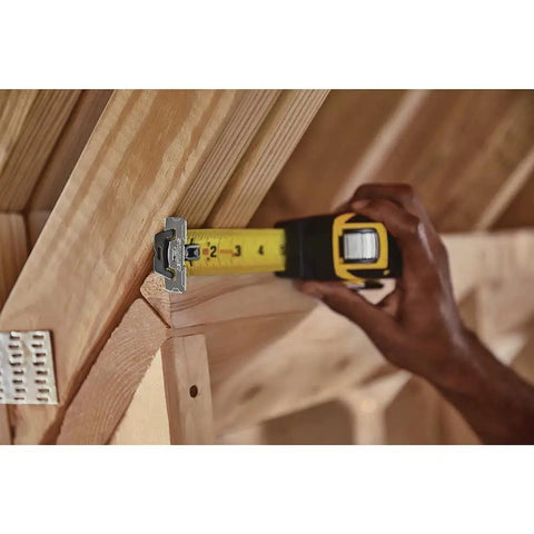 FatMax Auto Lock Tape Measure 25 Ft With 1-1/4 Inch Wide Blade Detachable End Hook in use measuring wooden beam