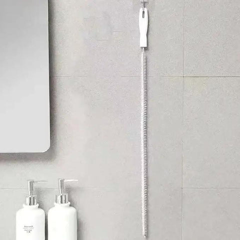 Flexible Drain Snake Cleaner Brush That Kicks Out Greasy Gunk Reusable Spiral Hair Removal Tool With Comfort Grip Handles For Sinks Showers And Bathtubs In White hanging on wall.