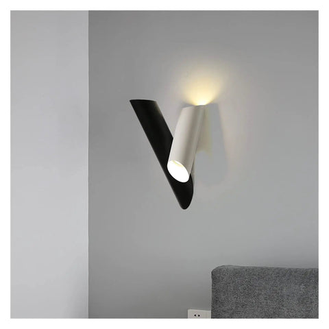 Rock Solid Black Iron Wall Sconce With Pivot Led Fixture And Chill Warm Glow Modern Minimalist Bedside Lighting mounted on grey wall.