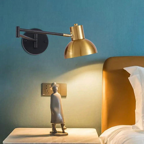 Badass Industrial Metal Swing Arm Wall Sconce With Rock Solid Adjustable Dome Shade And E27 Socket Hella Sturdy For Bedroom Reading Vibes And Slick Black Brass Finish Modern Wall Lamp with brass shade next to bedside table.