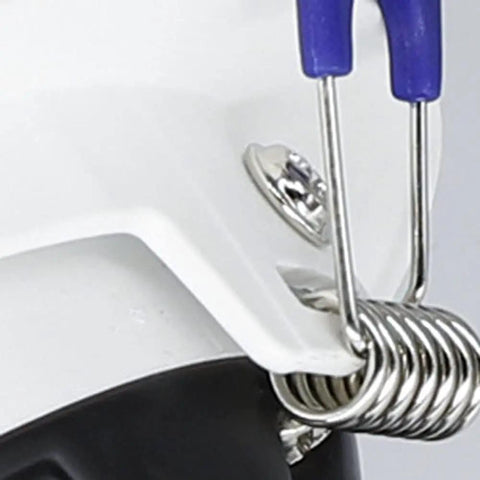 Close-up of a white safety helmet with a blue and silver attachment on the side, showcasing metal and plastic details.
