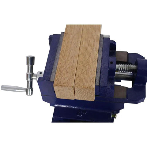 4 Inch X Y Cross Slide Drill Press Vise With Heavy Duty Steel Construction and Hardened Replaceable Serrated Jaws holding wooden pieces.