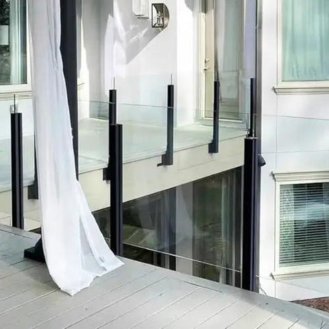 Top Tier Black Glass Railing Kit With Stainless Steel Deck Support, sleek black posts and glass panels on a modern balcony.
