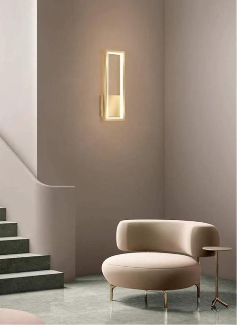 Super Tight 16W Gold LED Wall Sconce With Dimmable Rectangle Frame And Switchable Warm Natural White Glow To Honestly Level Up Your Bedroom Or Living Room Setup With Zero Fuss At All mounted next to stylish chair in modern interior.