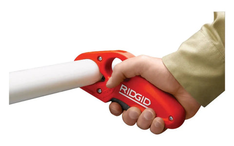 Hand using PTEC 30000 Pro Grade Tubular Tailpiece Extension Cutter One And A Quarter Inch Red With Auto Deburr And Bevel on PVC pipe