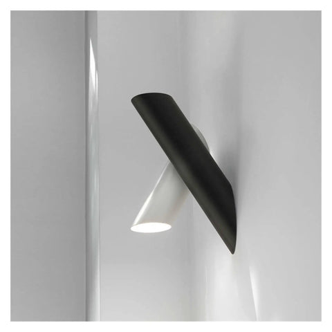 Rock Solid Black Iron Wall Sconce With Pivot Led Fixture And Chill Warm Glow Modern Minimalist Bedside Lighting on gray wall.