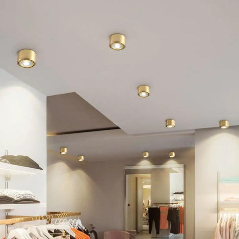 8 Pack Brass Trim Retrofit LED Recessed Lighting Tough As Nails Copper Housing Directional Eyeball Downlights Triple Switch 3000K To 6500K Clean Smooth Glow installed in a retail space.