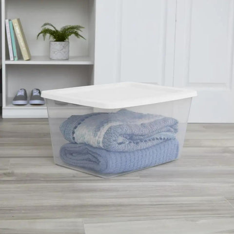 Kick The Junk Clutter Aside With These Ridiculously Spacious Clear Plastic Storage Containers Featuring Hassle Free Snap On Lids Straight Outta The Box Ready To Tame Your Garage Tools And Closet Stash Massive 58 Quart Capacity 8 Pack Included clear plastic storage container with blankets inside on wooden floor.
