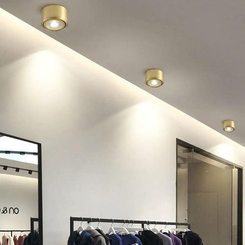 8 Pack Brass Trim Retrofit LED Recessed Lighting Tough As Nails Copper Housing Directional Eyeball Downlights Triple Switch 3000K To 6500K Clean Smooth Glow installed in modern retail setting.