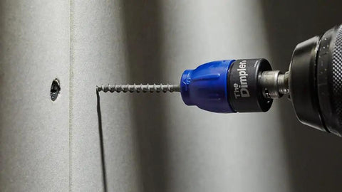 Close-up of Drywall Dimpler Screw Setter With Automatic Countersink And Preset Depth, driving screw into drywall.