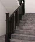 Rock Solid Black Poplar Wood Balusters And Stair Spindles For Deck Railing System 38 Inch installed on stair railing with gray steps.