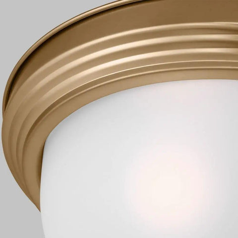 Close-up of satin brass 3 light flush mount ceiling light in Geary style with etched glass, modern look, steel construction.