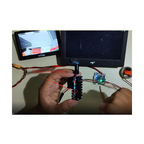 Hands adjusting Beefed-Up 5.8 Gigahertz 2000mW FPV Transmitter For Drones With 20km Range 8-Channel Video TX With 5dBi SMA Antenna
