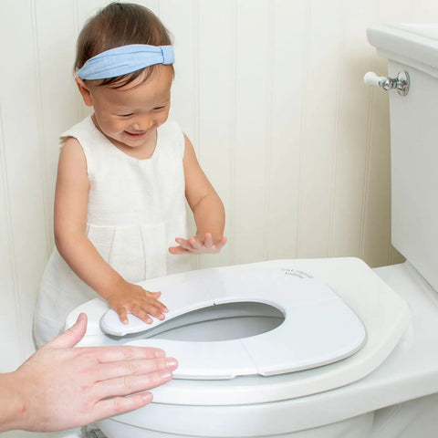 Child using a Foldable Travel Potty Seat For Toddlers on a standard toilet, demonstrating ease of use and support.