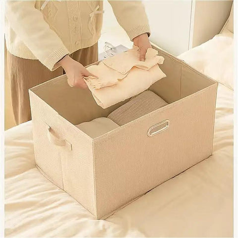 Person placing folded clothes into a Heavy Duty Fabric Storage Bin With Snap On Lids Stackable Khaki Storage Box.