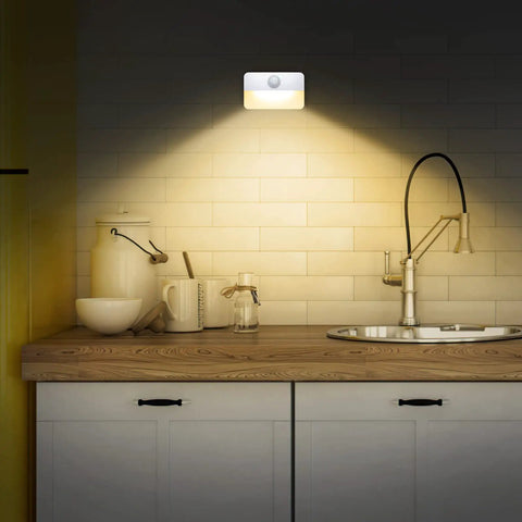 4 Pack Mini Motion Sensor Stair Lights Battery Powered Cordless LED Night Lights illuminating kitchen countertop at night