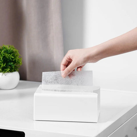 Hand pulling a dryer sheet from Hecka Rugged Magnetic Dryer Sheet Holder For Laundry Room With Heavy Duty Magnet Mount.